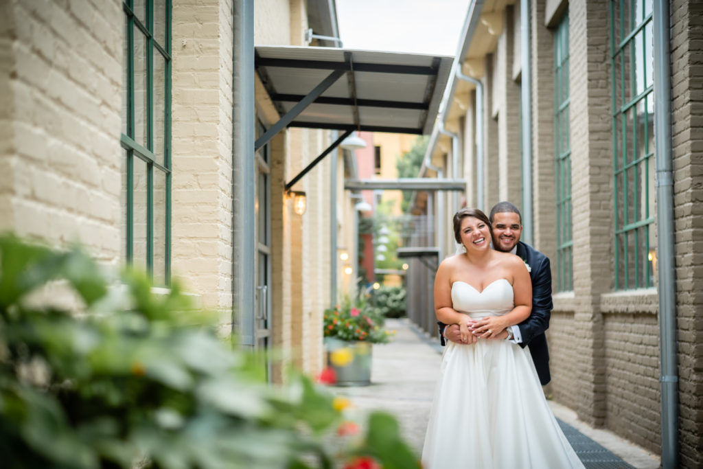 Newly married couple hugging in alley behind The Foundry at Puritan Mill in Atlanta Georgia