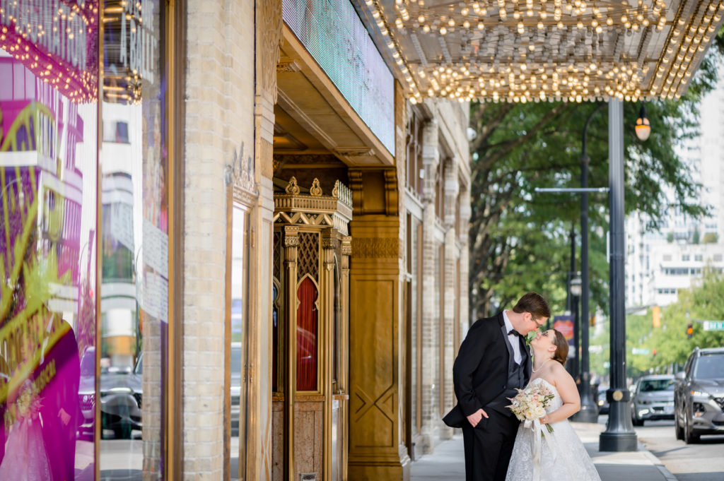Married couple kissing under marquee at The Fox Theater in Atlanta Georgia