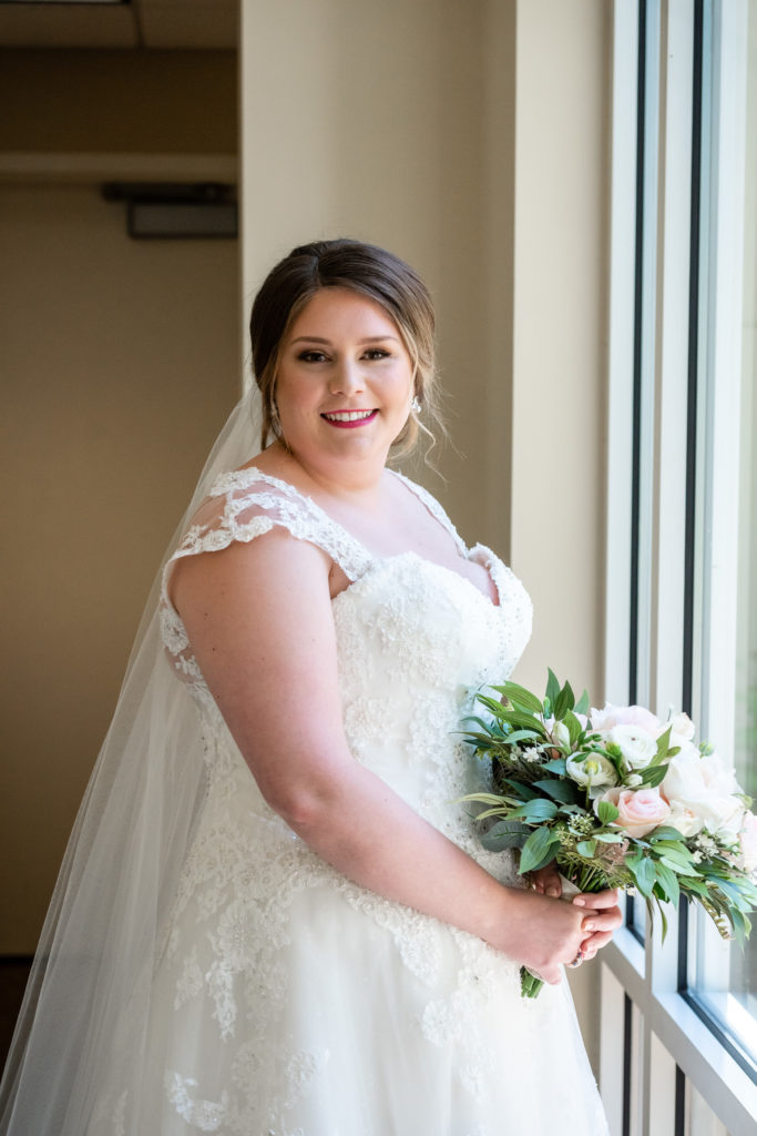 Bride smiling at the camera by the window