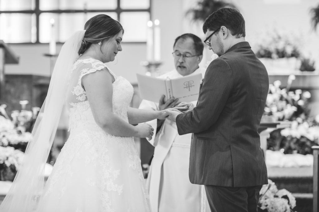 Bride and groom exchanging rings at St Andrew Catholic Church in Roswell, GA