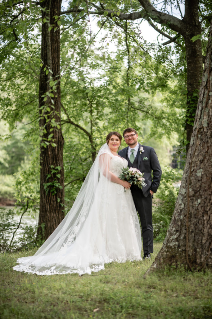 Bride and groom looking at the camera while standing in the park in Roswell, GA