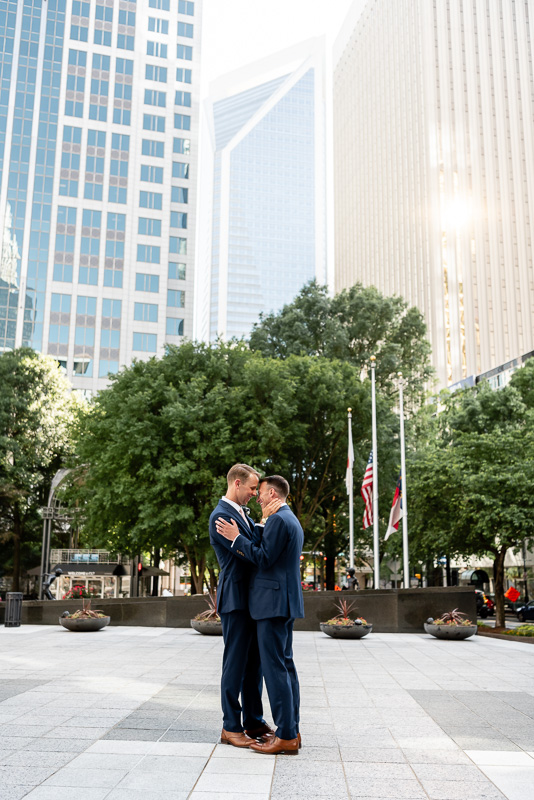 couple hugging in front of skyline in Uptown Charlotte North Carolina