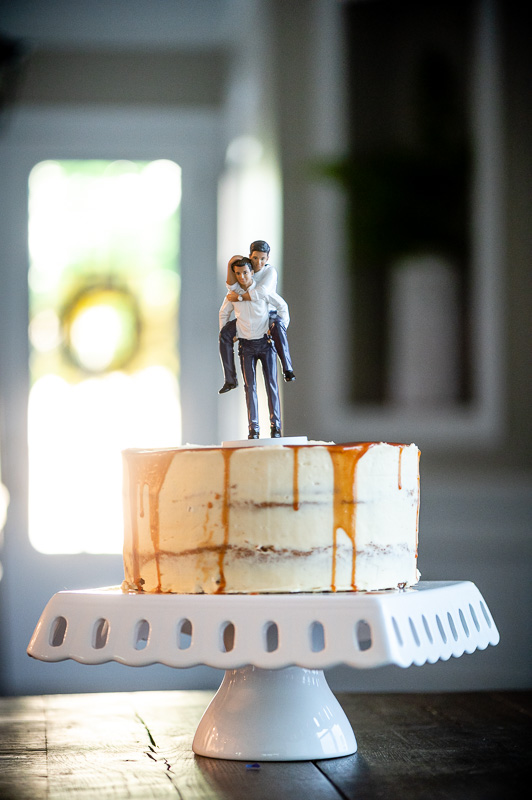 wedding cake with fun cake topper where couple is doing piggy back ride in Charlotte North Carolina