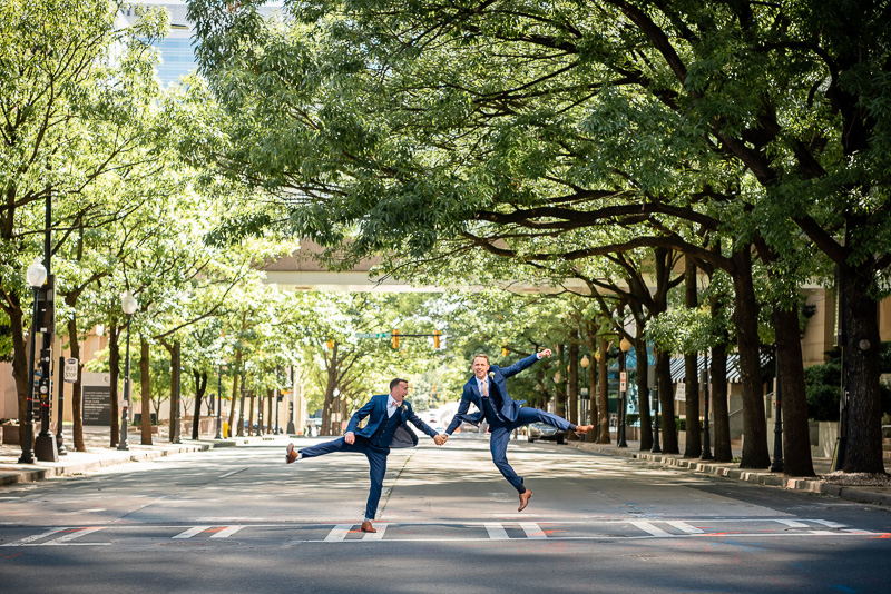 Two grooms clicking their heels on a cross walk in Uptown Charlotte NC