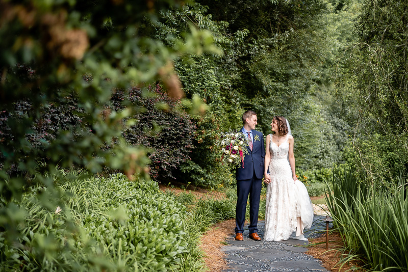 Bride and groom standing on a stone path while looking at each other at the Little Gardens wedding venue in Lawrenceville, GA