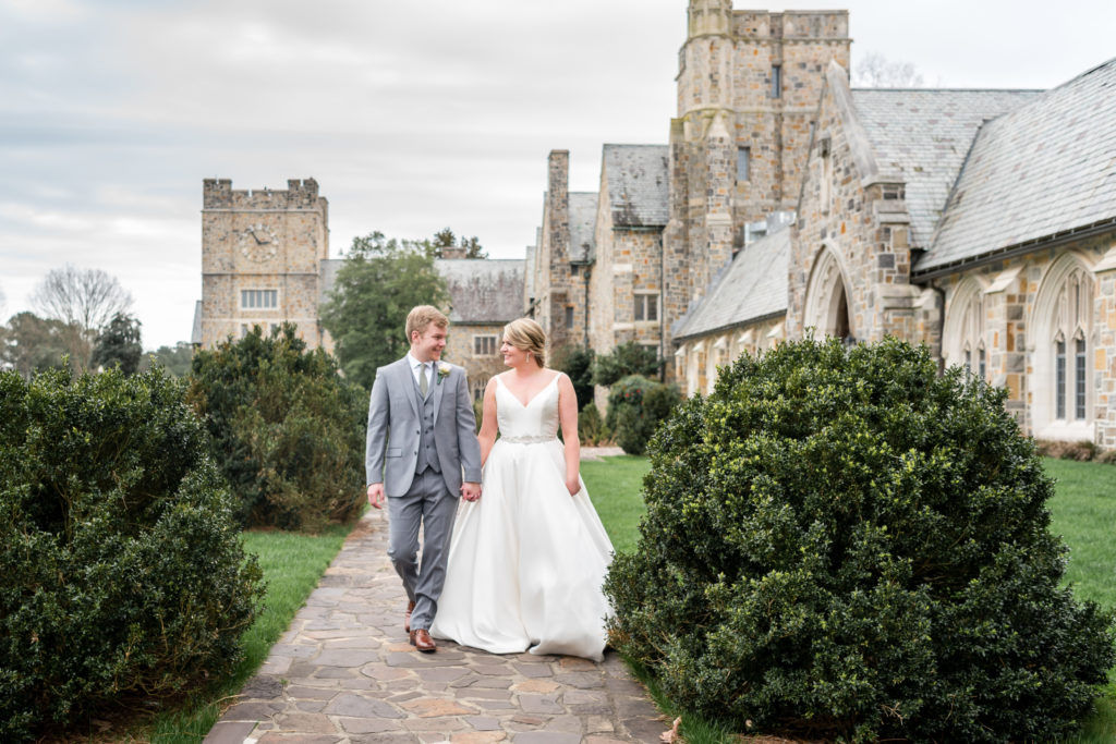 Photo of bride and groom walking on a stone path at Berry College by the castles