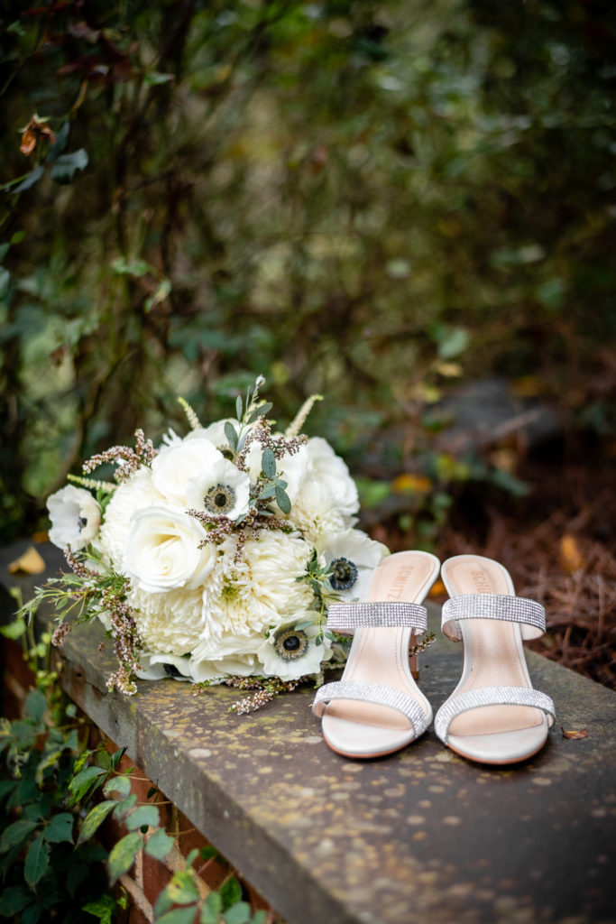 Bridal bouquet and heels on stone wall at intimate, backyard wedding in Marietta GA