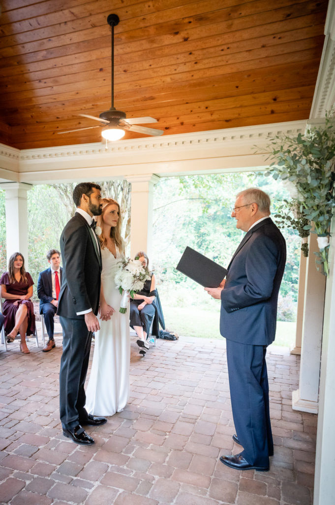 Wedding ceremony and vows being read at intimate, backyard wedding in Marietta GA