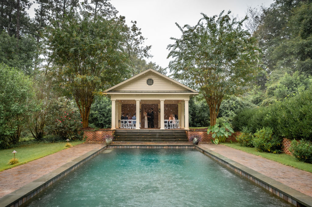 Wide shot of poolhouse where ceremony is taking place at intimate, backyard wedding in Marietta GA