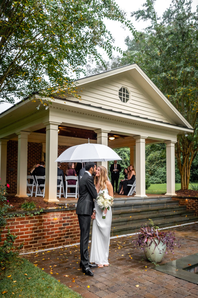 Bride and groom kissing at the end of the aisle after ceremony at intimate, backyard wedding in Marietta GA
