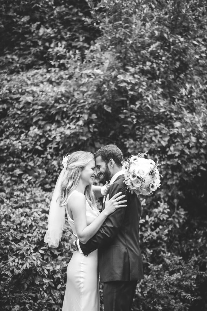 Black and white photo of bride and groom forehead to forehead for portrait at intimate, backyard wedding in Marietta GA
