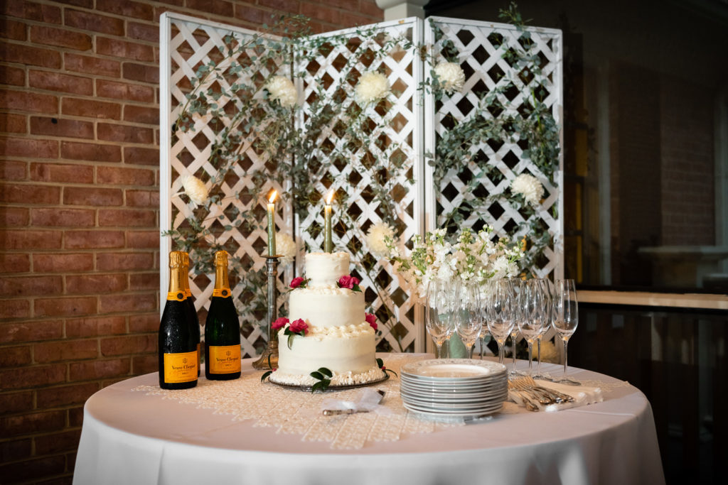 Cake table with champagne and florals at intimate, backyard wedding in Marietta GA
