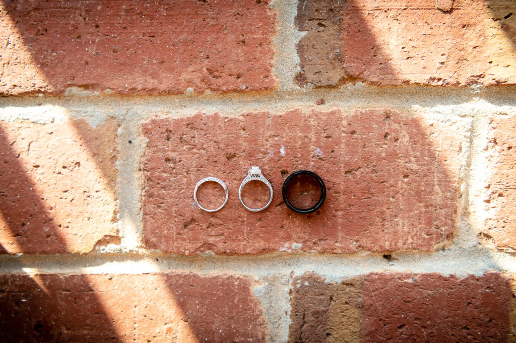 Photo of wedding rings on brick floor at wedding at The Gavi Estate and Barn in Forsyth GA