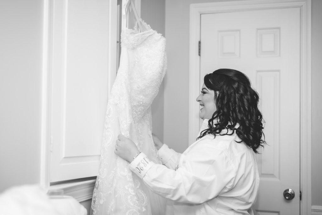 Photo of bride gazing at her dress at at wedding at The Gavi Estate and Barn in Forsyth GA