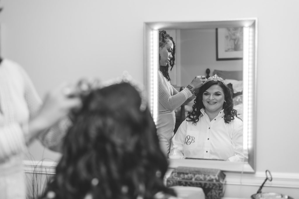 Photo of bride getting her hair and crown touched up at wedding at The Gavi Estate and Barn in Forsyth GA