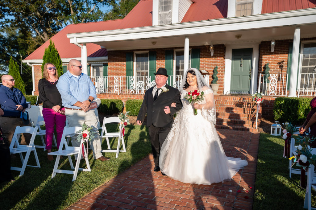 Bride walking down the aisle with her dad at wedding at The Gavi Estate and Barn in Forsyth GA