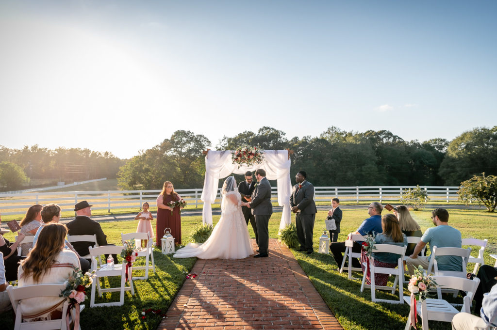 bride and groom at the alter during their ceremony at wedding at The Gavi Estate and Barn in Forsyth GA