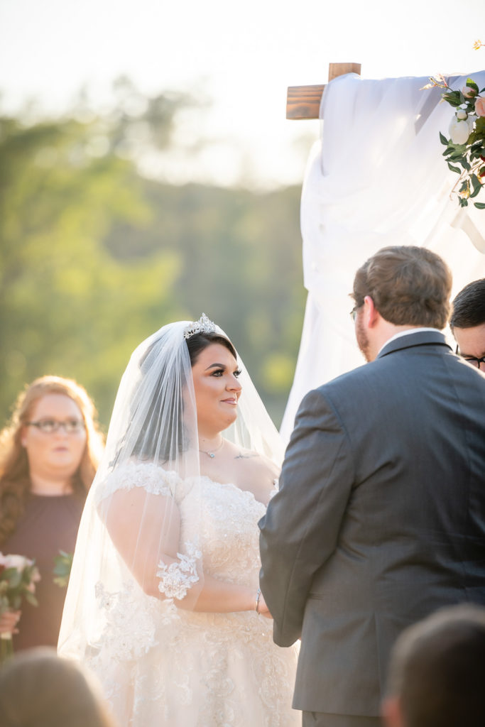 bride gazing at her groom at the alter at wedding at The Gavi Estate and Barn in Forsyth GA