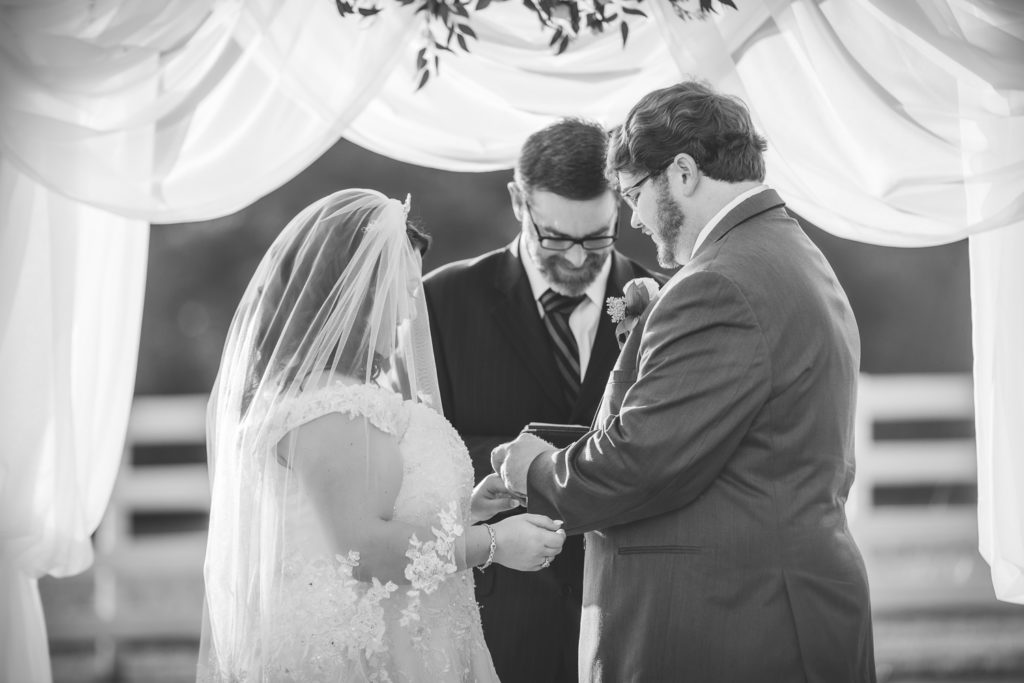 bride and groom exchanging rings at wedding at The Gavi Estate and Barn in Forsyth GA