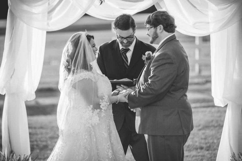 bride and groom exchanging rings at wedding at The Gavi Estate and Barn in Forsyth GA