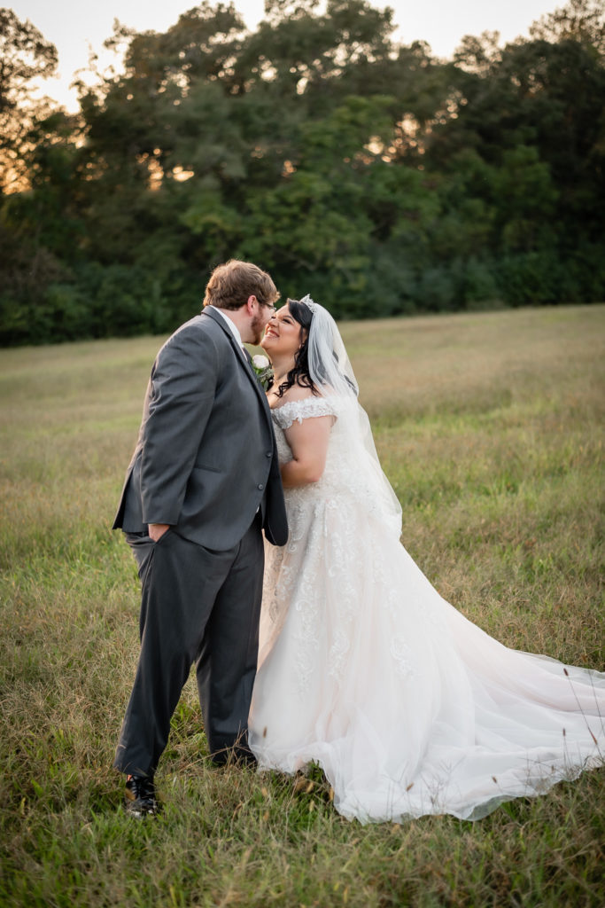 Portrait of bride & groom standing in open field at sunset at wedding at The Gavi Estate and Barn in Forsyth GA