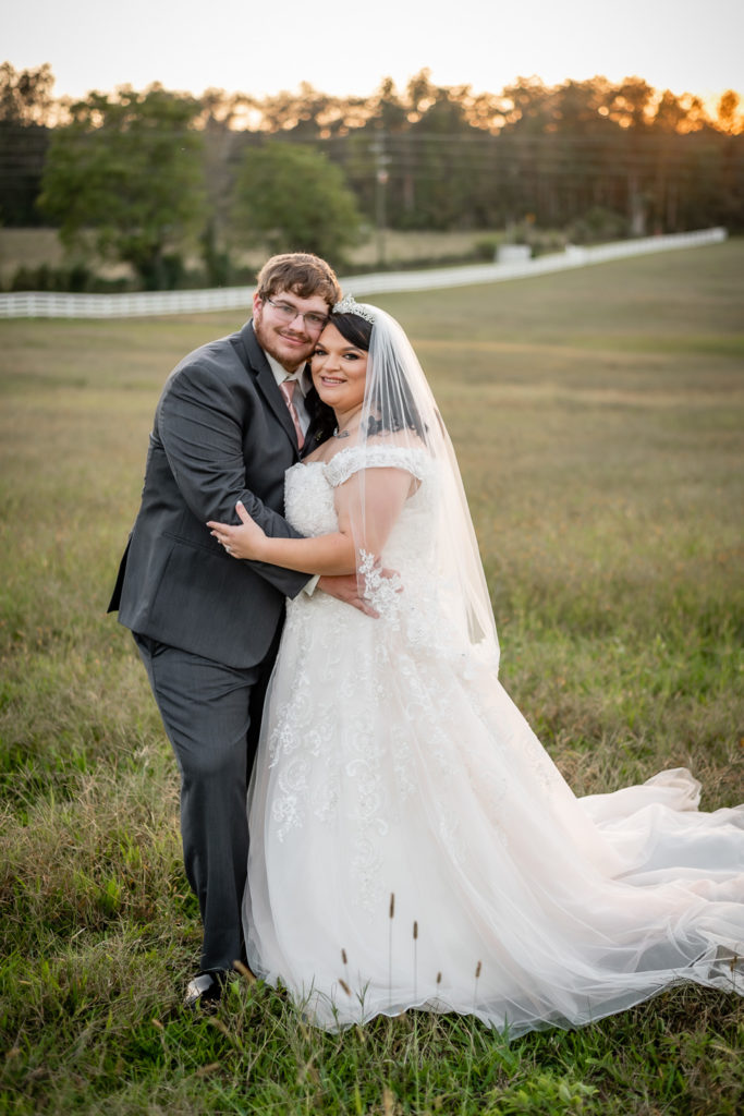Portrait of bride & groom standing in open field at sunset at wedding at The Gavi Estate and Barn in Forsyth GA