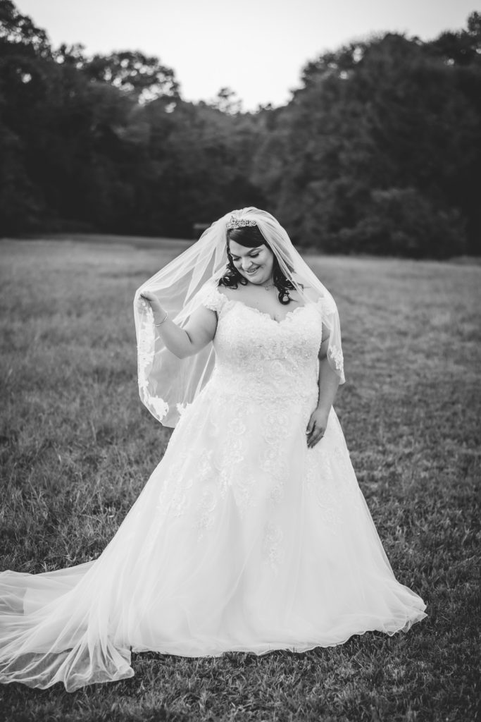 Portrait of bride standing in open field at sunset at wedding at The Gavi Estate and Barn in Forsyth GA