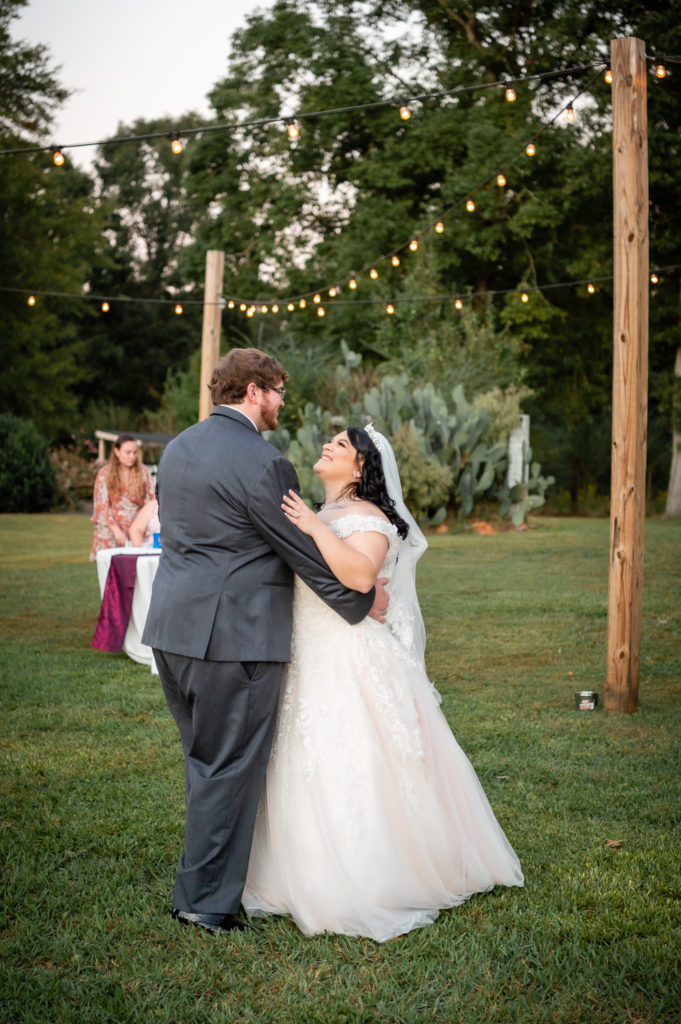 Bride and groom dancing outside under twinkling lights at wedding at The Gavi Estate and Barn in Forsyth GA