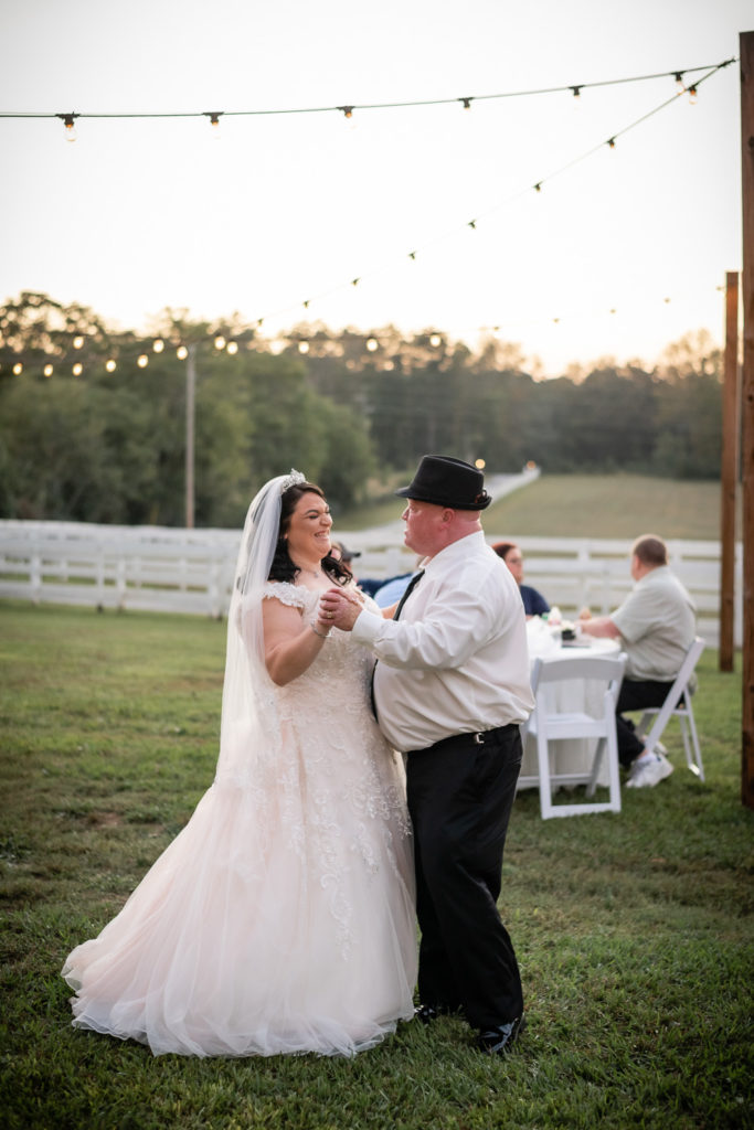 Bride and father of the bride dancing outside under twinkling lights at wedding at The Gavi Estate and Barn in Forsyth GA