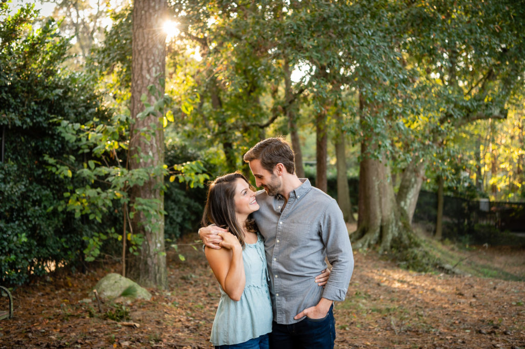 couple standing in the woods during golden hour