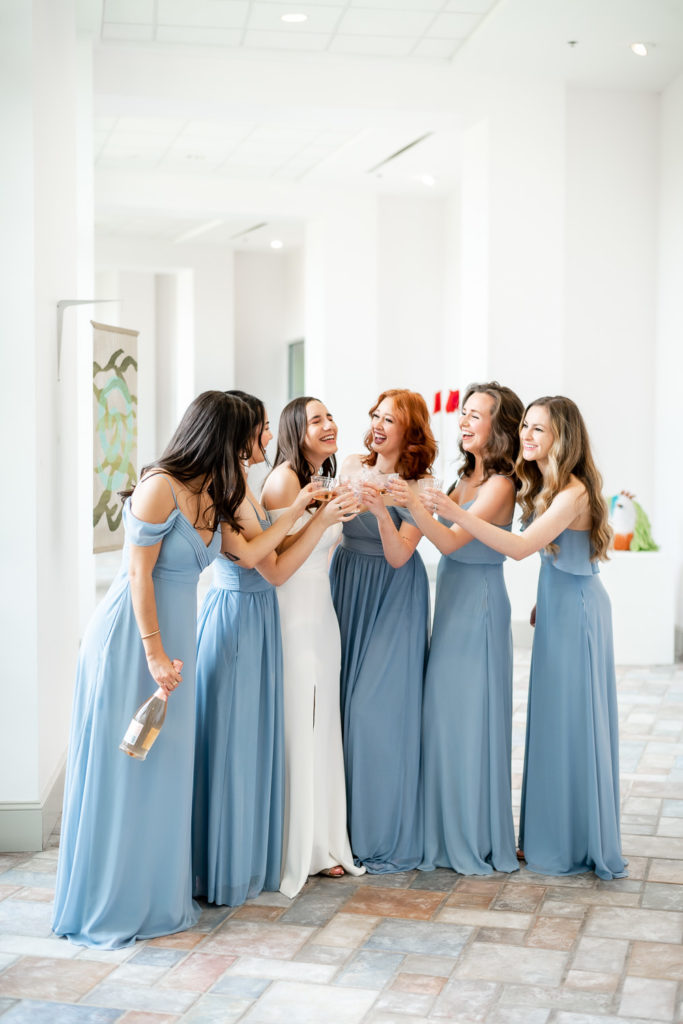 bride and bridesmaid cheering with champagne on the wedding day at The Hudgens Center for Art and Learning in Atlanta Georgia