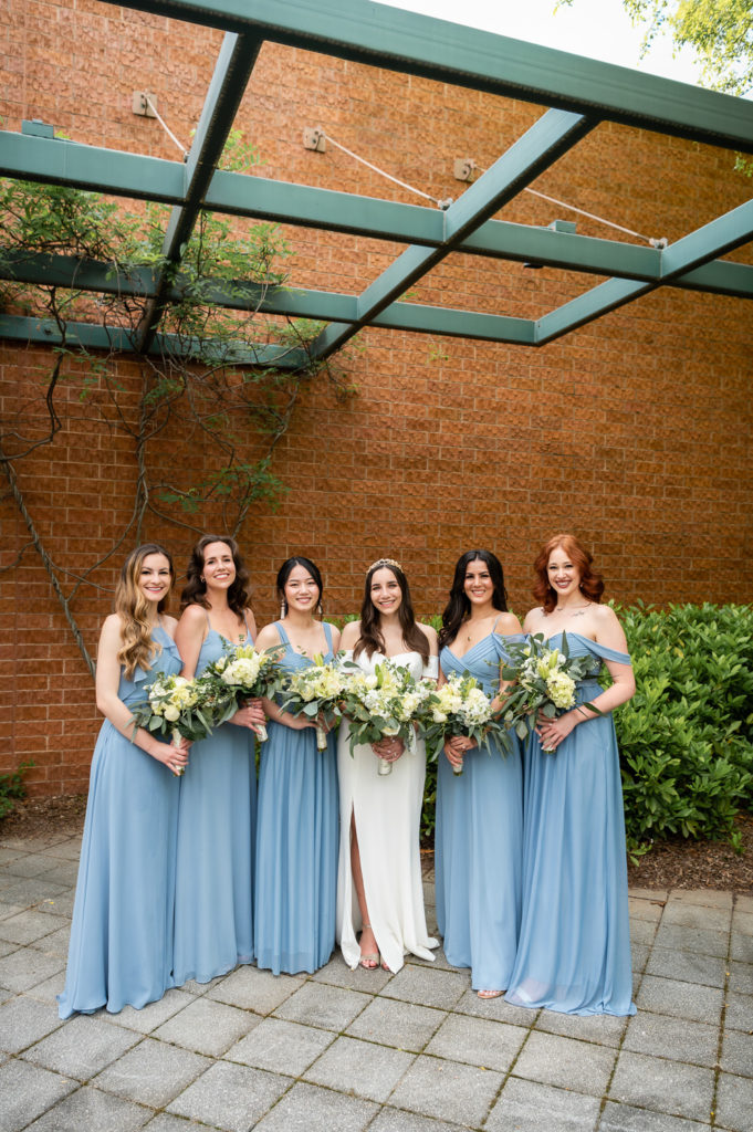bridesmaids standing in front of brick wall on the wedding day at The Hudgens Center for Art and Learning in Atlanta Georgia