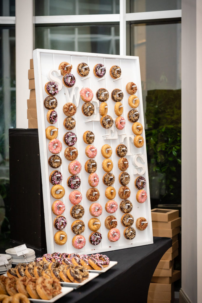 donut wall and sweets and bride and groom at reception on the wedding day at The Hudgens Center for Art and Learning in Atlanta Georgia
