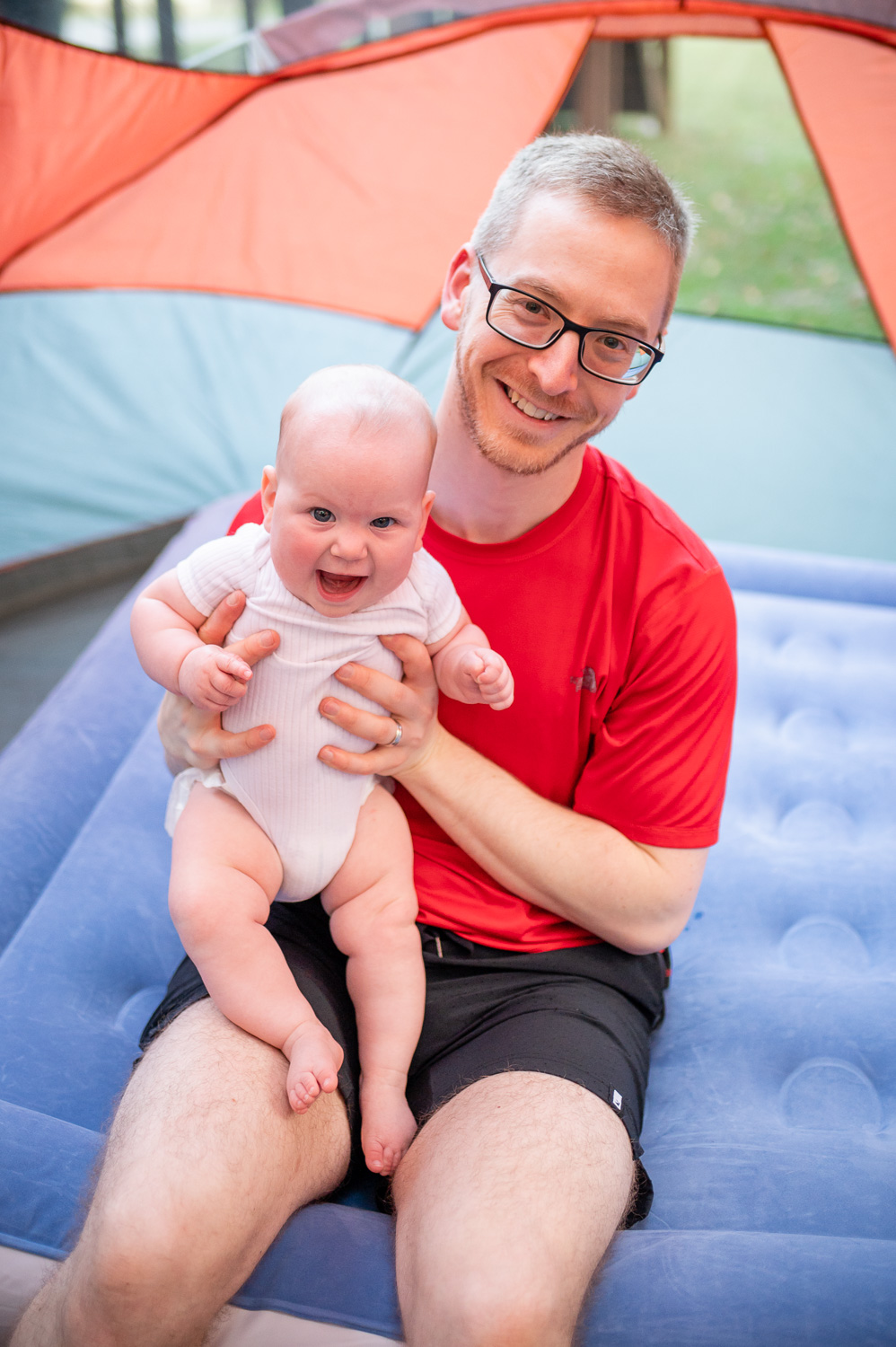 Dad holding baby in tent